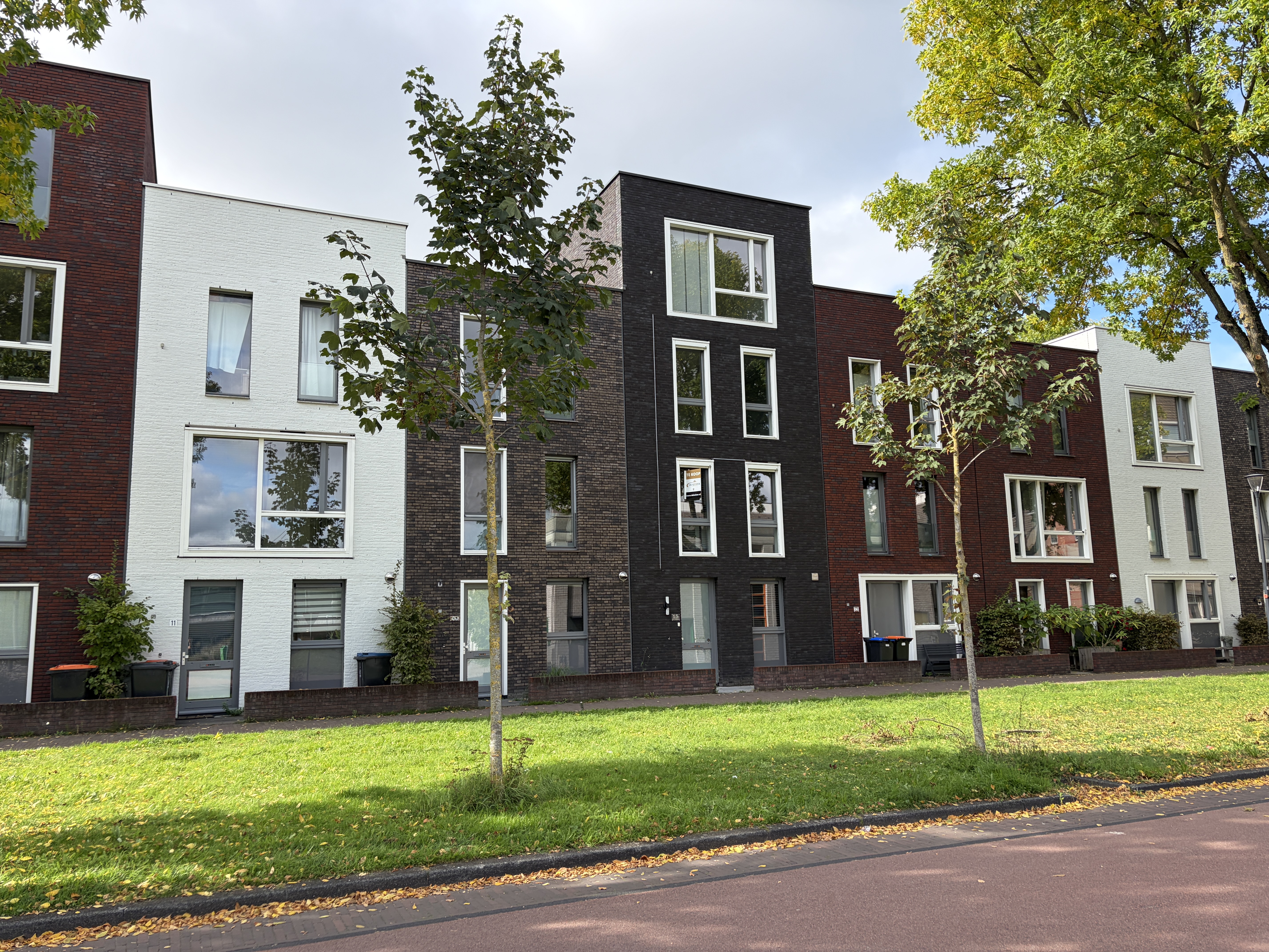 Voorgevel van De Slinger 15 in Houten: donkere baksteen met witte kozijnen